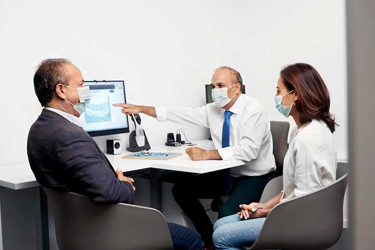 Image show HearingLife audiologist talking with man and a woman