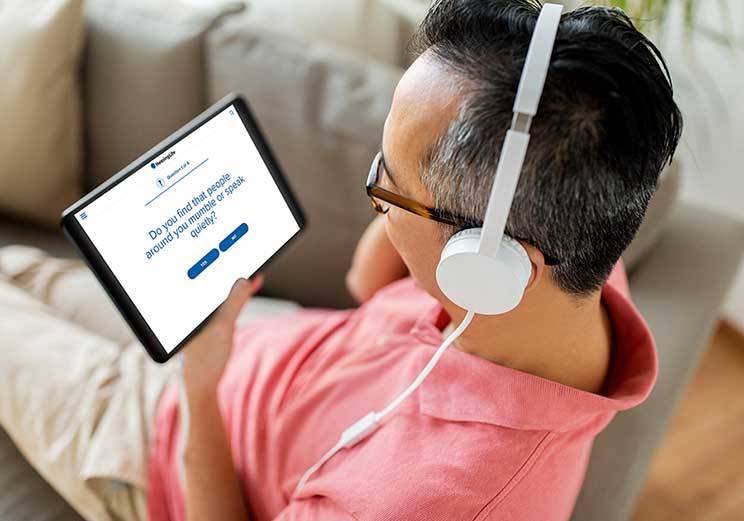 Image show man taking an online hearing test