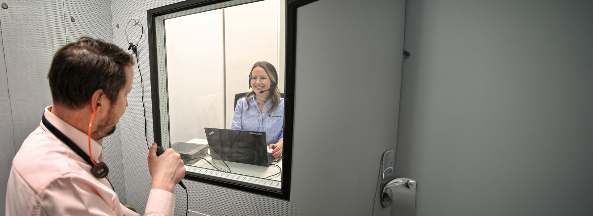 Image shows woman during hearing test with headphones on