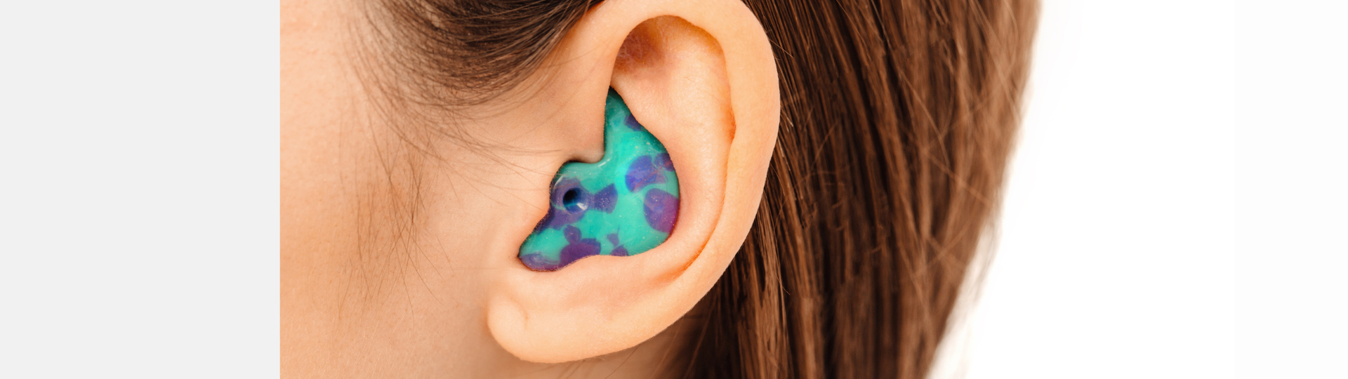 person with a brightly colored ear plug in their ear