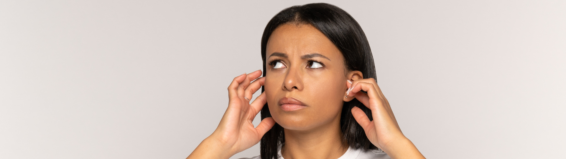 woman with tinnitus holding her ears