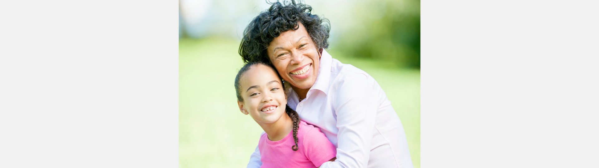 woman and a child hugging while outside in the sunshine