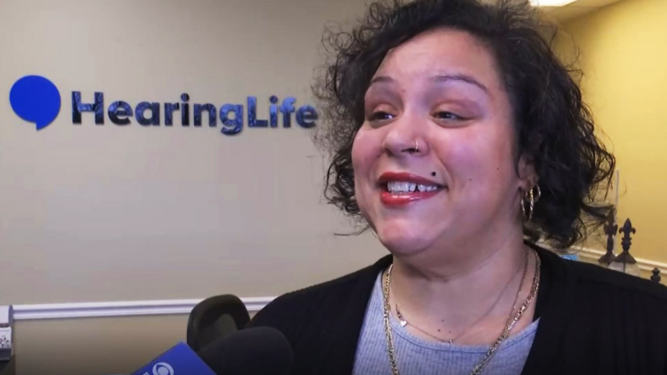 a woman speaks with the media about her hearing aids from campaign for better hearing