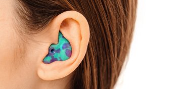 person with a brightly colored ear plug in their ear