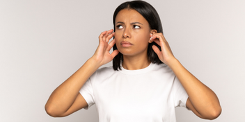 woman with tinnitus holding her ears
