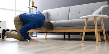 person looking under a couch