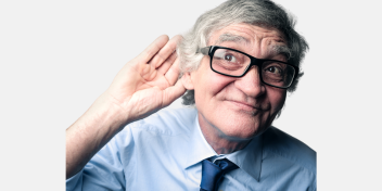 older man holding his hand up to his ear
