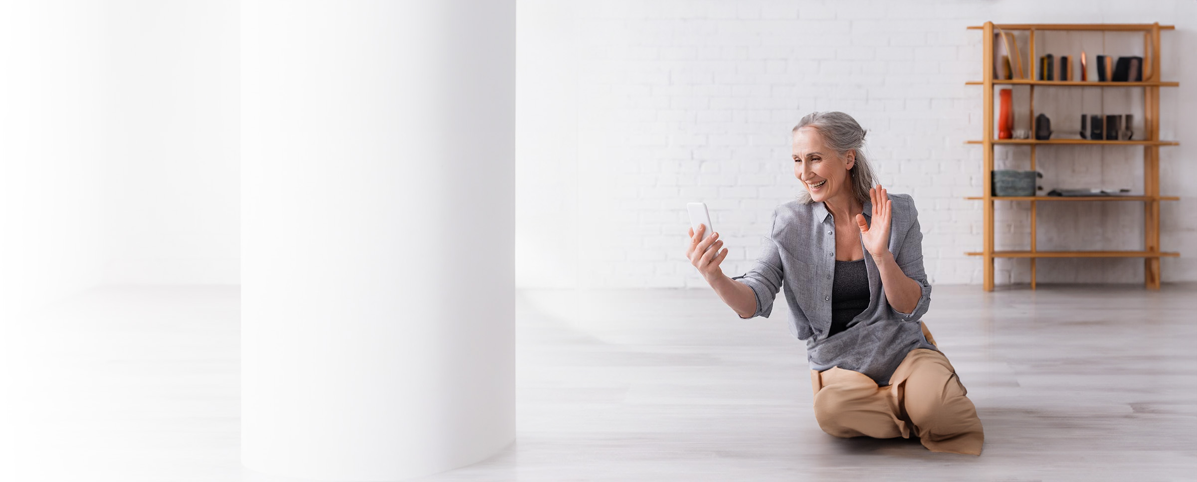 Woman smiling and waving at the phone