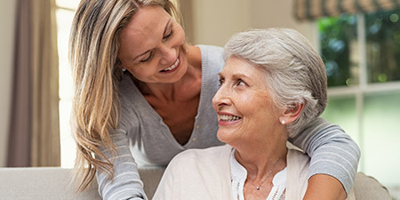 an older woman and a younger woman talking and smiling
