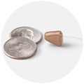 Oticon Own hearing aid next to two Quarters for size comparison