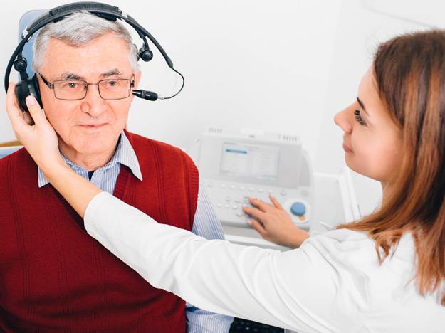 Audiologist giving hearing test to person with headphones