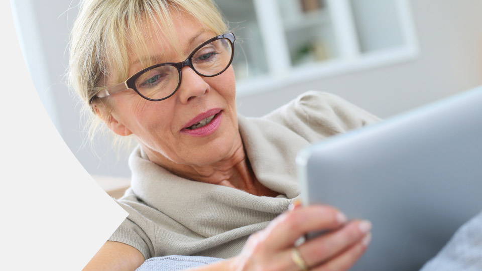 image shows woman smiling looking at a tablet