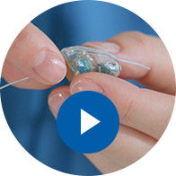 Image show hands change battery in a hearing aid