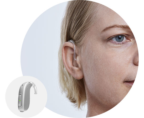 Image shows woman wearing behind-the-ear hearing aid